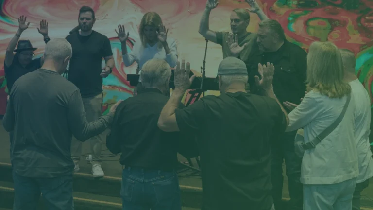 Group of people with hands raised, praising together