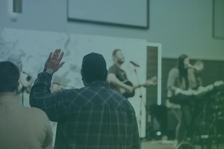 Group of people worshipping together with hands raised